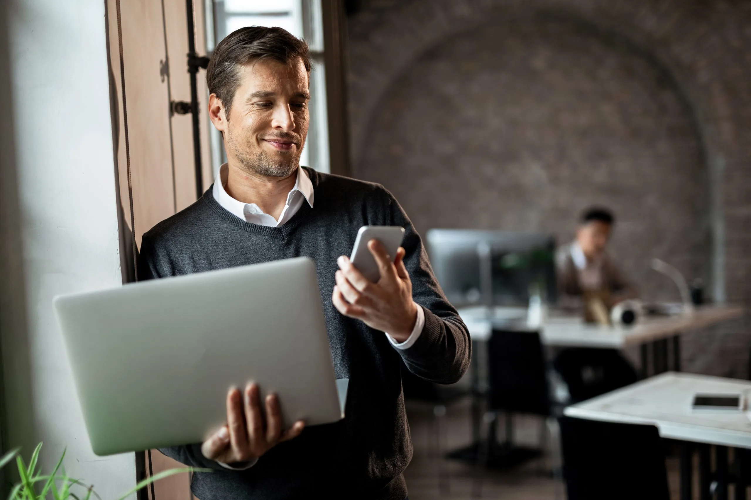 Empresario usando celular e notebook com acesso a contabilidade a qualquer hora